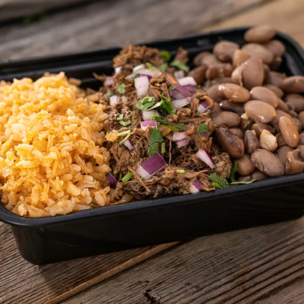 Mexican takeout container with rice, shredded beef with onions and cilantro, and pinto beans.