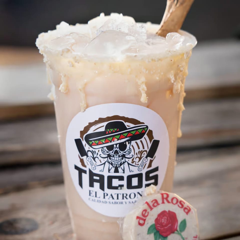 A Tacos El Patron horchata drink with ice and a de la Rosa mazapan candy.